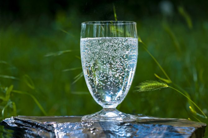Mineralwasser-Glas auf Stein