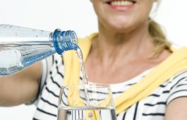 Best Agerin schenkt Mineralwasser ein